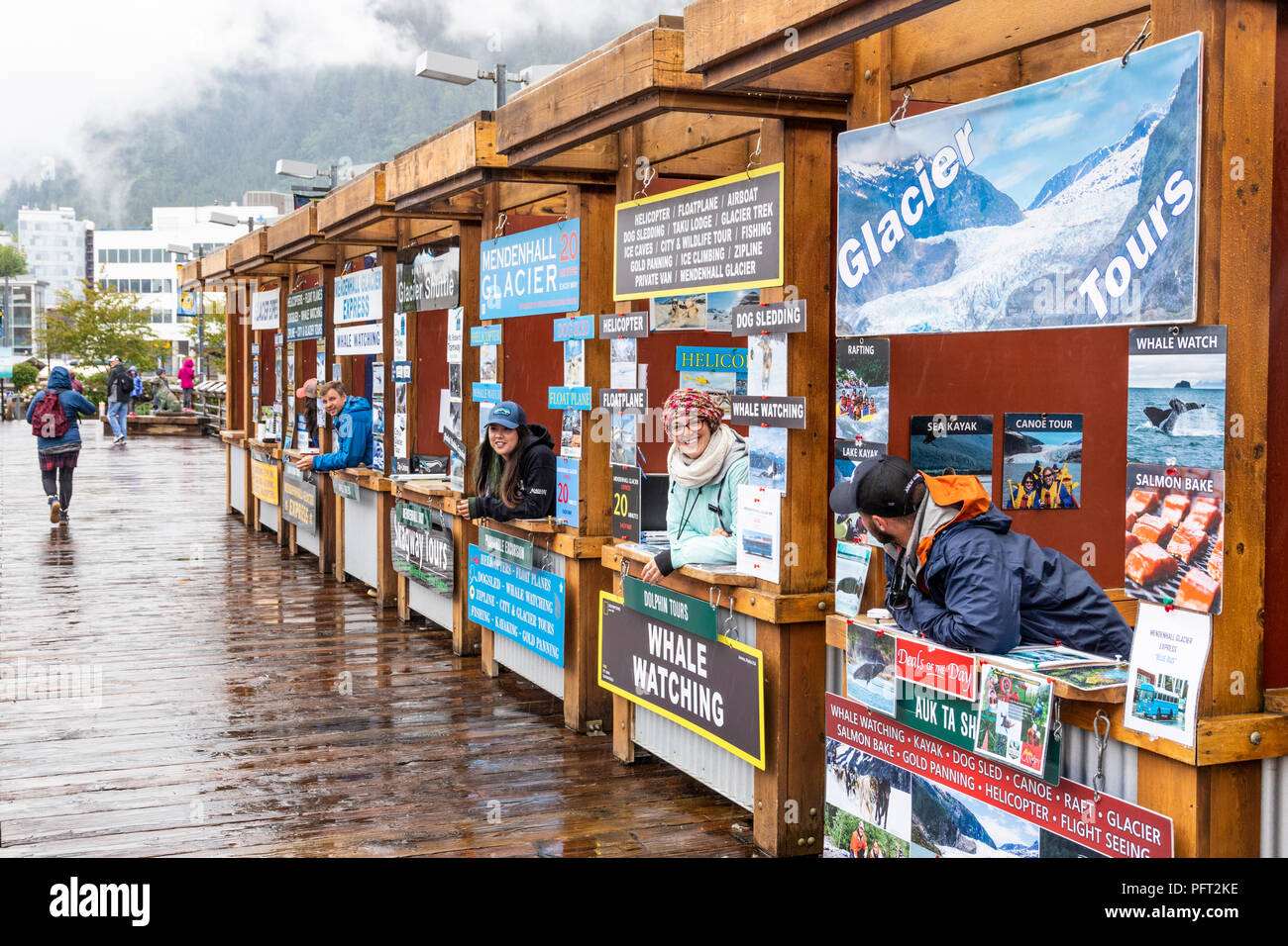 I tour operator si spera reclamizza per business su un piuttosto giorno piovoso nel porto di Juneau la città capitale di Alaska, STATI UNITI D'AMERICA Foto Stock