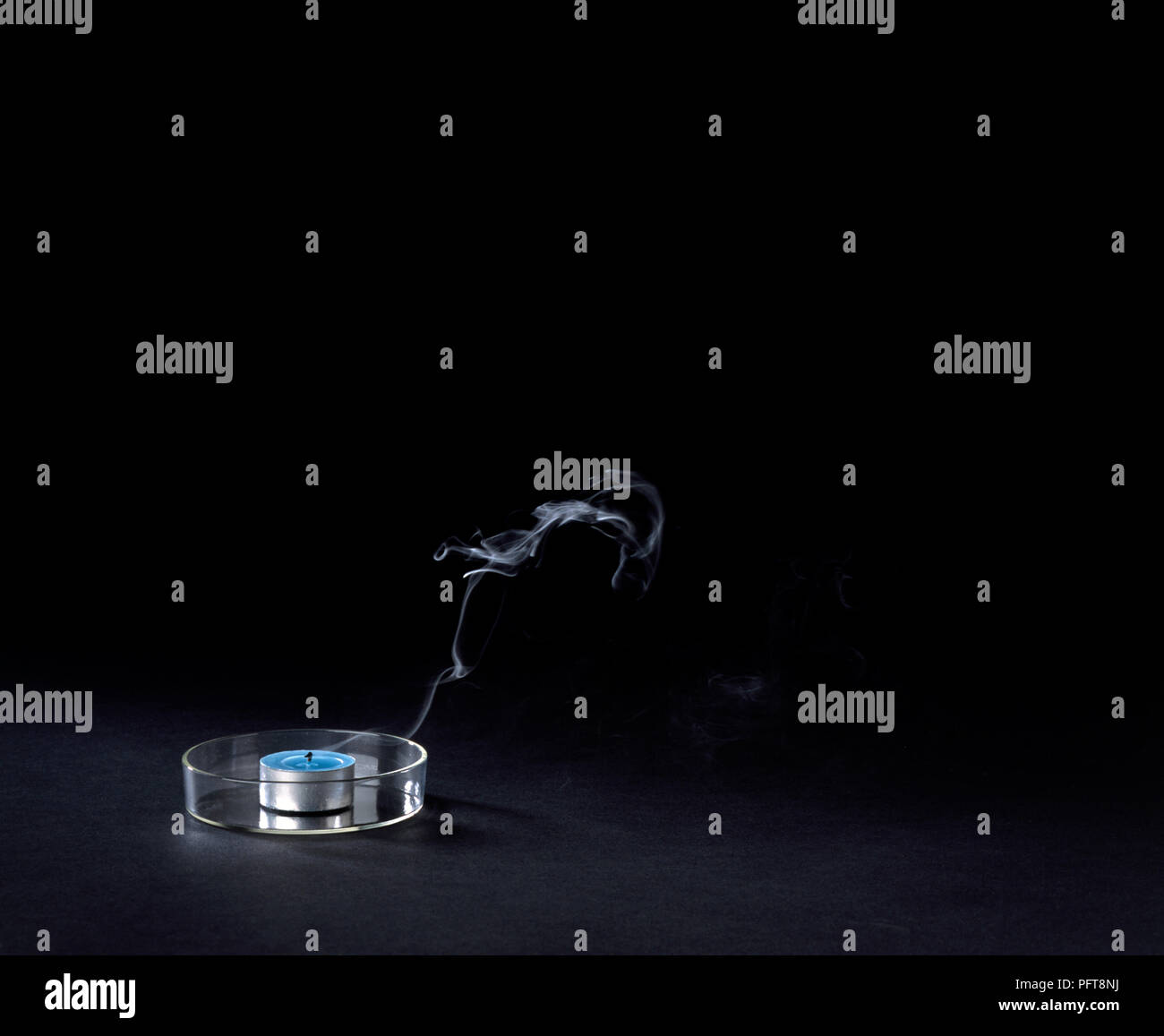 Il fumo proveniente da spenta tealight su sfondo nero Foto Stock
