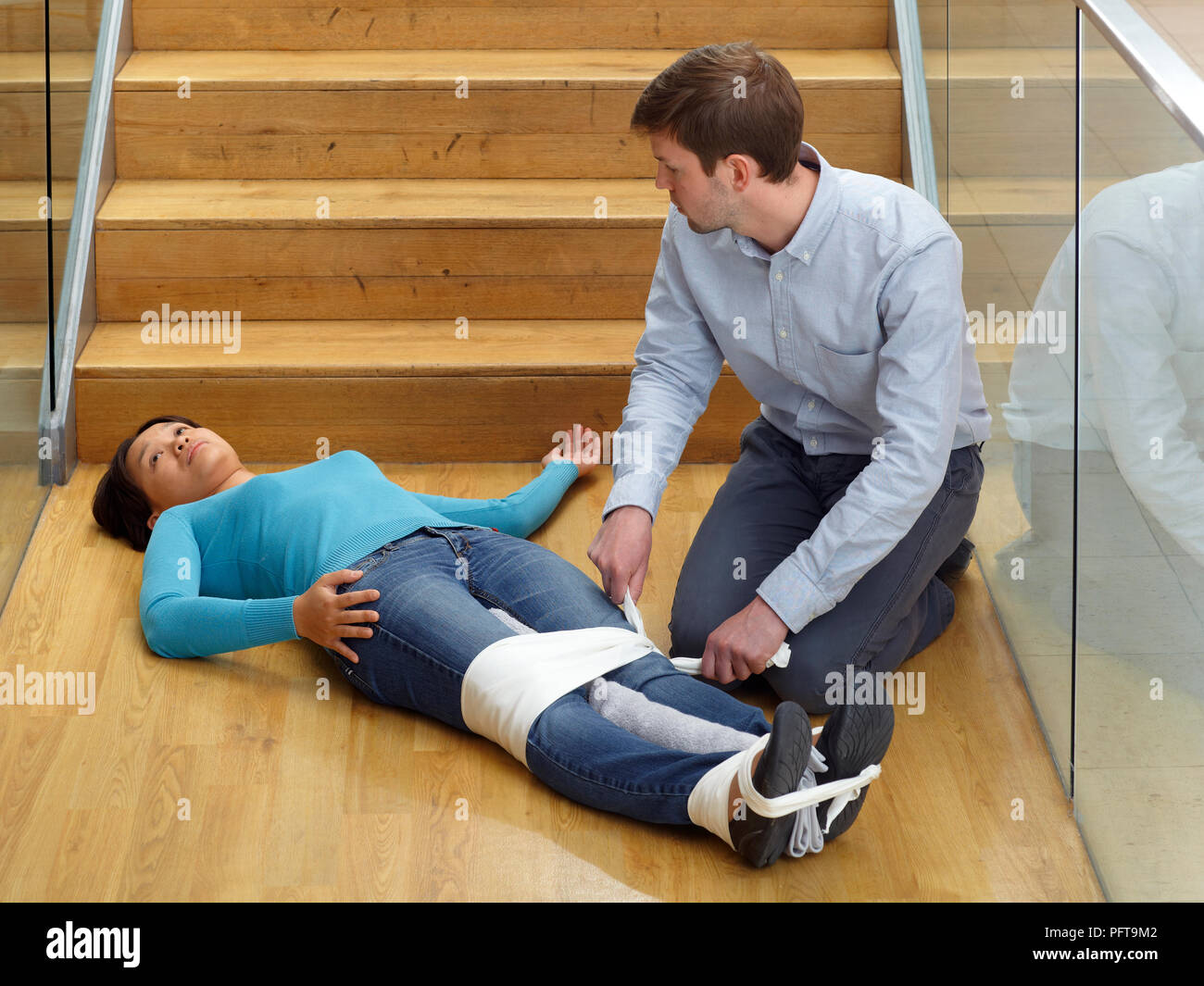 Primo soccorso lesioni pelvico fratturato o bacino di trattamento, fasciature gambe insieme Foto Stock