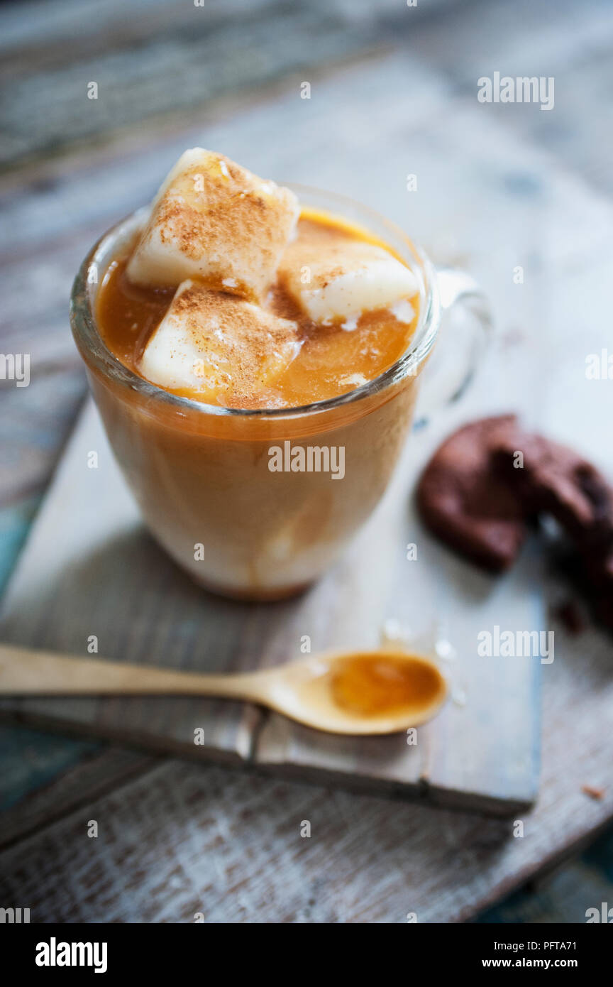 Latte e miele caffè ghiacciato, ghiacciato cubetti di latte e cannella Foto Stock