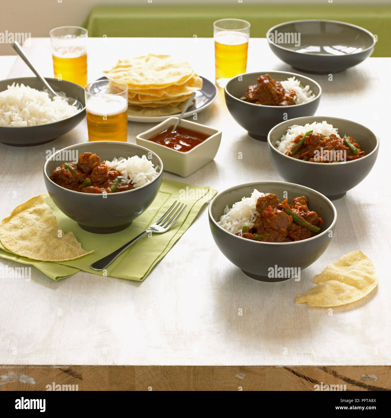 Aromatici curry di manzo con zenzero, pomodori, okra, servito con riso e pappadoms Foto Stock