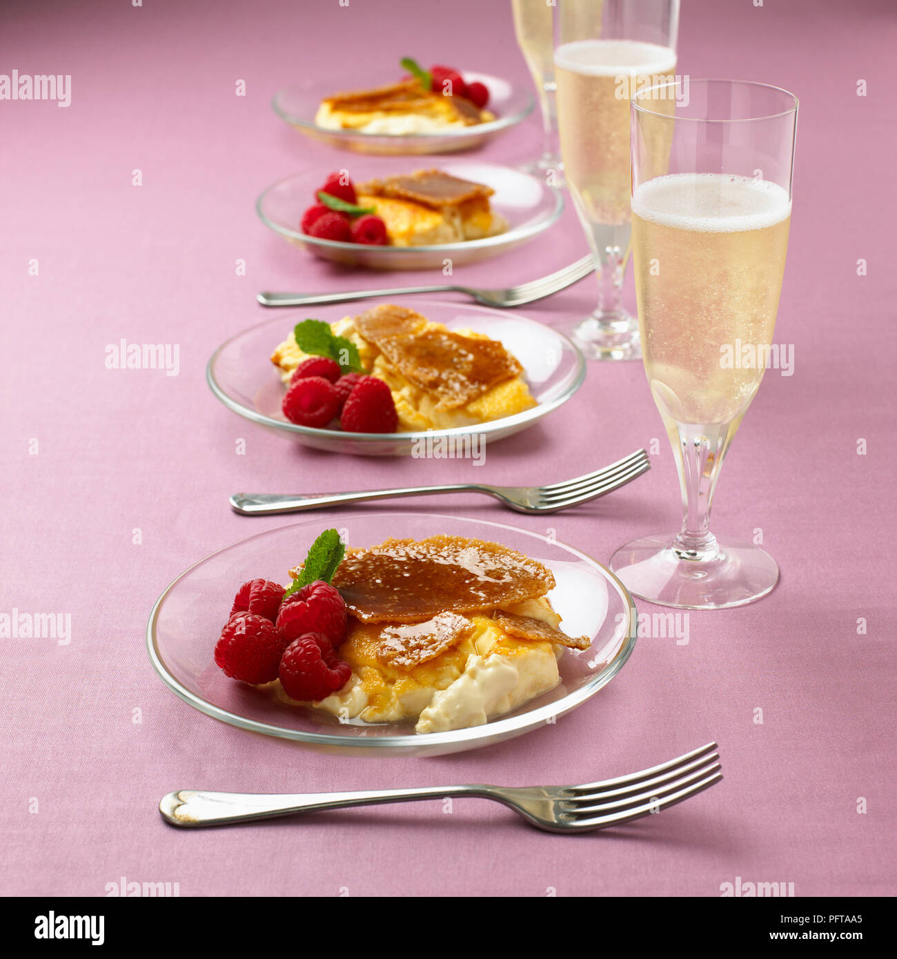 Creme brulee con lamponi freschi, bicchieri di champagne Foto Stock