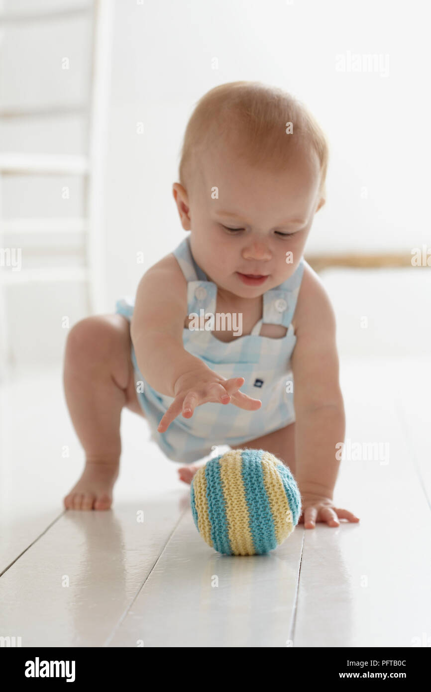 Baby girl, giocando con maglia giocattolo morbido sfera, 9 mesi Foto Stock