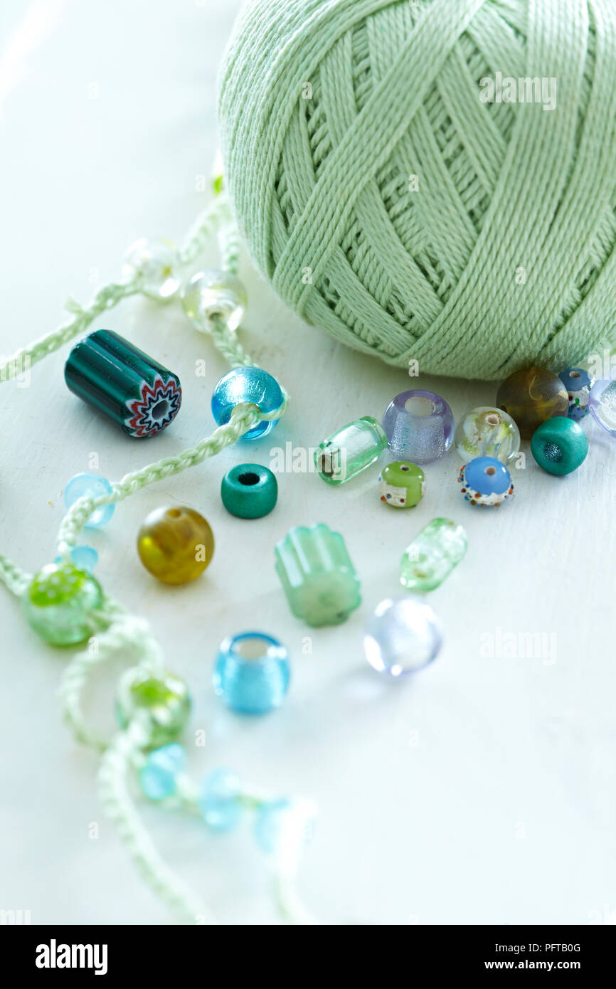 Filo verde e perle di vetro per rendere una collana Foto Stock