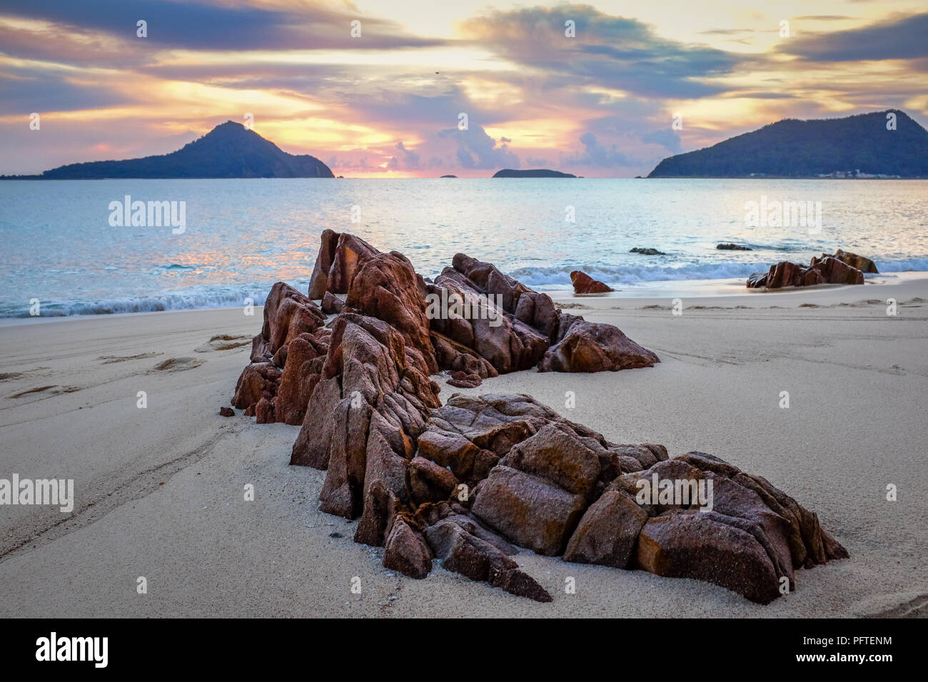 Sole che sorge sull'oceano e sulla spiaggia rocciosa Foto Stock