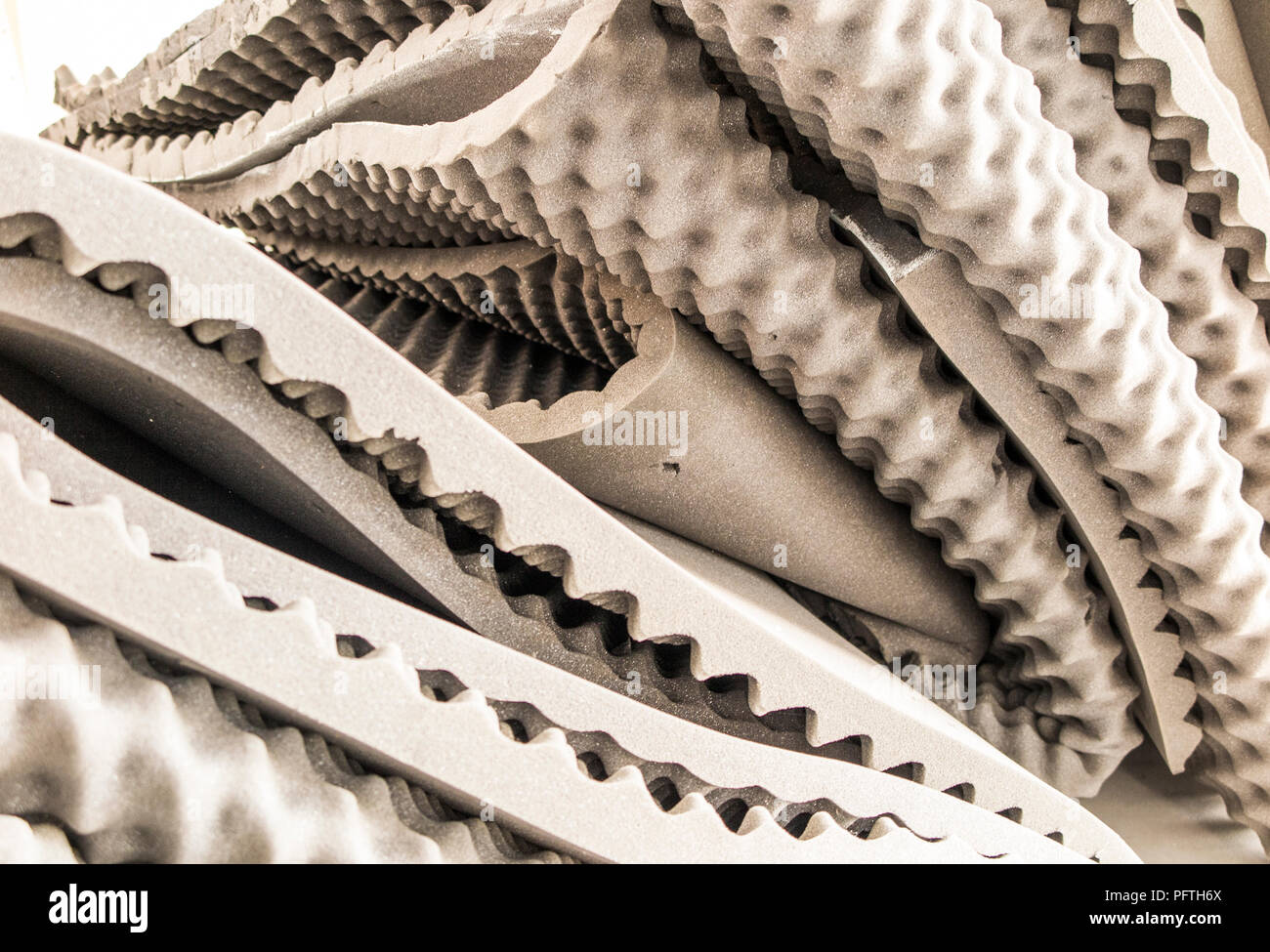 Uovo beige-cassa di sollievo di pressione materasso in schiuma tamponi, sovrapposizioni e topper preinstallato in una pila che mostra la superficie bugne cave, picchi e avvallamenti. Foto Stock