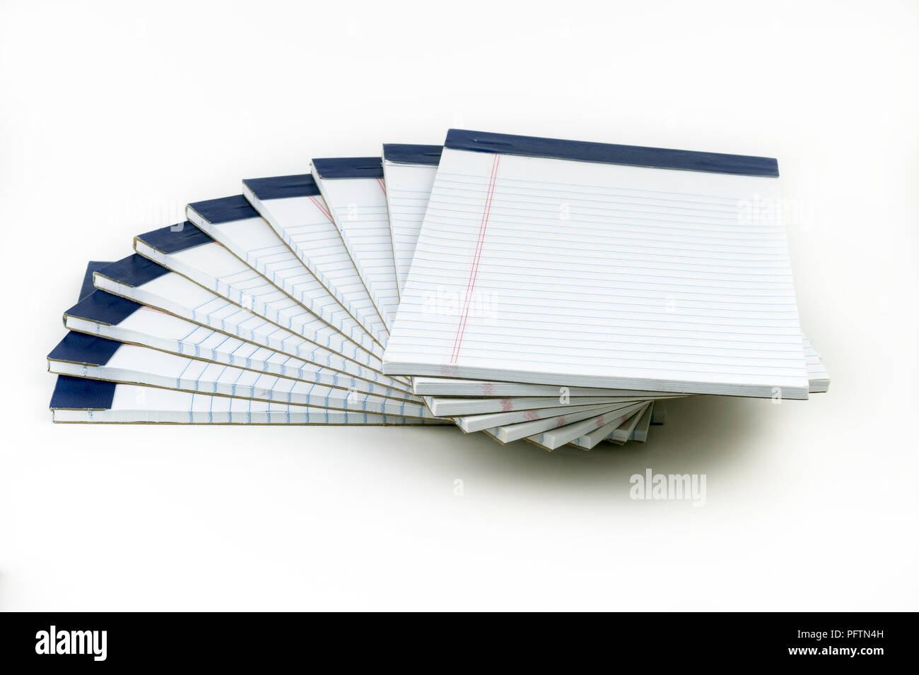 Una pila di bianco, governato notebpads con rilegatura blu, impilate in un modello a spirale. Questi potrebbero essere utilizzati come scuola o forniture per ufficio per prendere appunti e Foto Stock