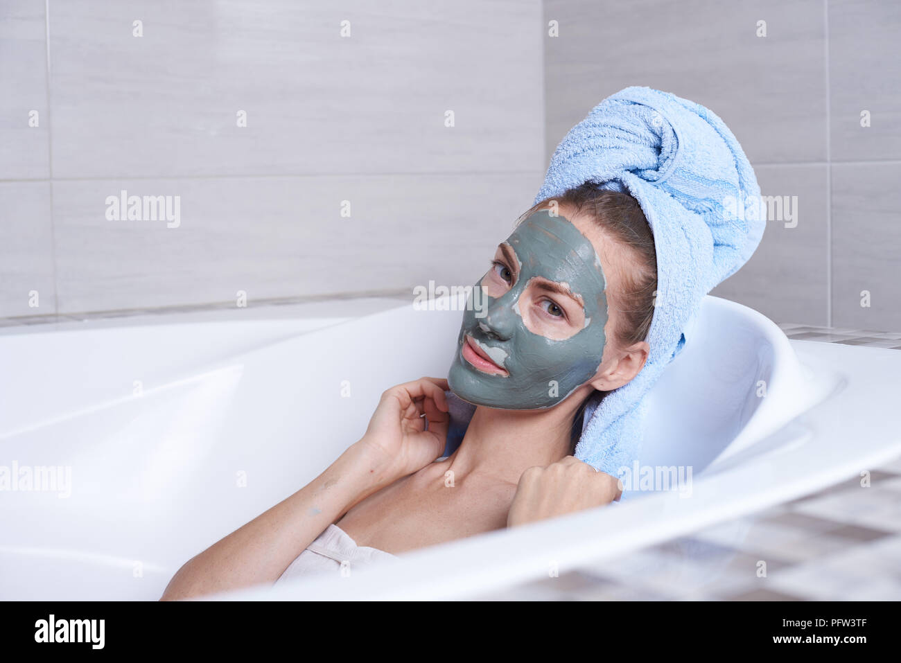 Ritratto di una donna in viso maschera di alginato giacente nel retro vasca  in bagno Foto stock - Alamy