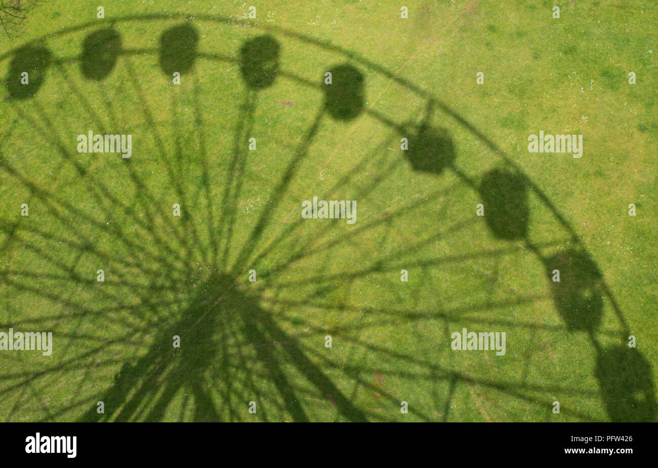 Ombra di Ferris Wheel (fiera grande ruota) sull'erba a Worthing West Sussex, in Inghilterra Foto Stock
