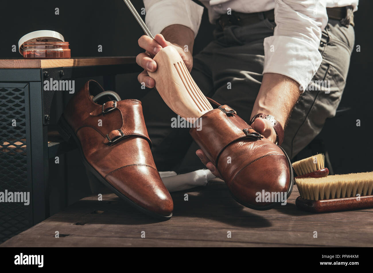 Bootblack prepara le scarpe per la pulizia nel suo laboratorio Foto Stock