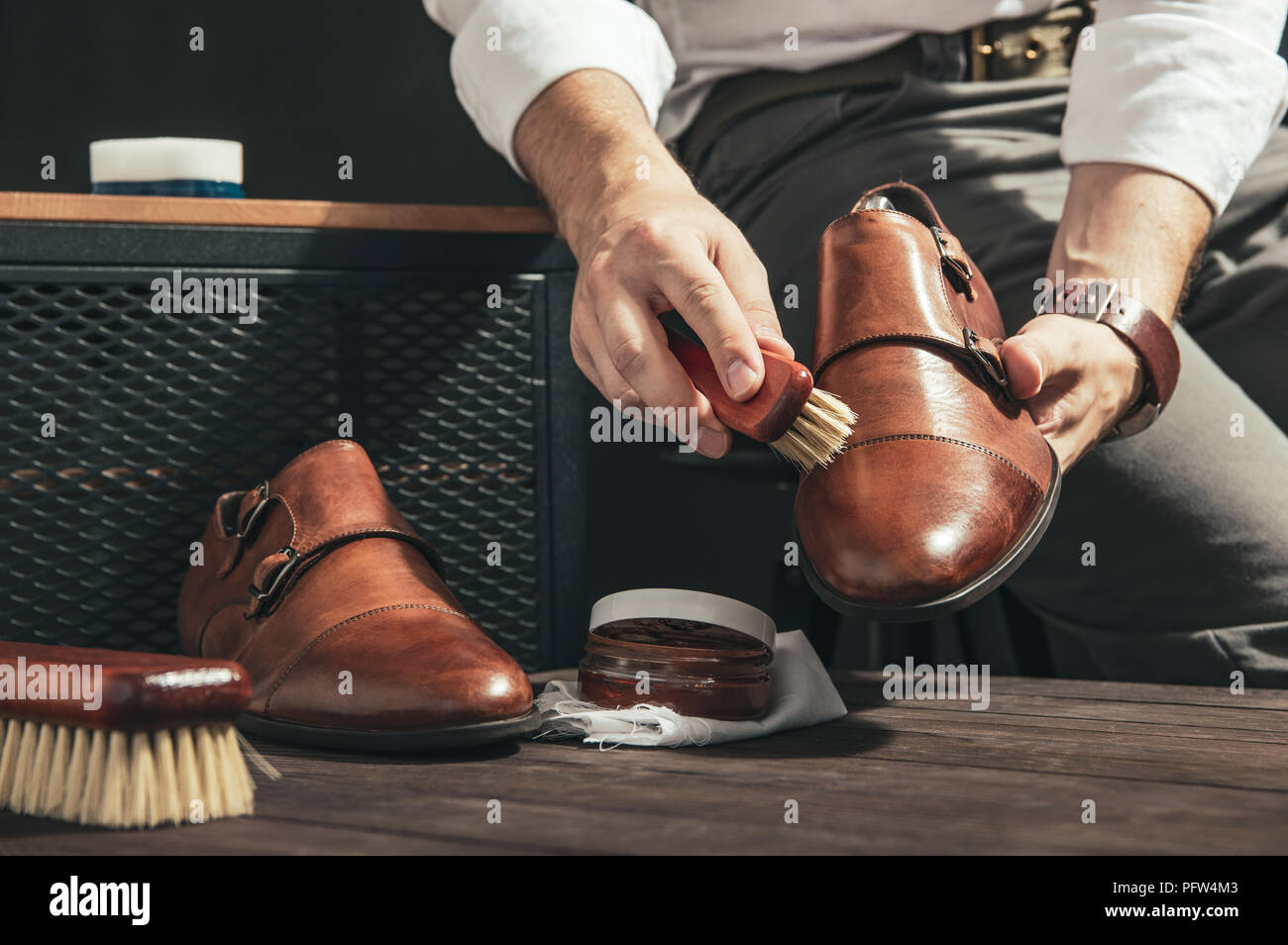 L'uomo vale shoe polish con una piccola spazzola Foto Stock