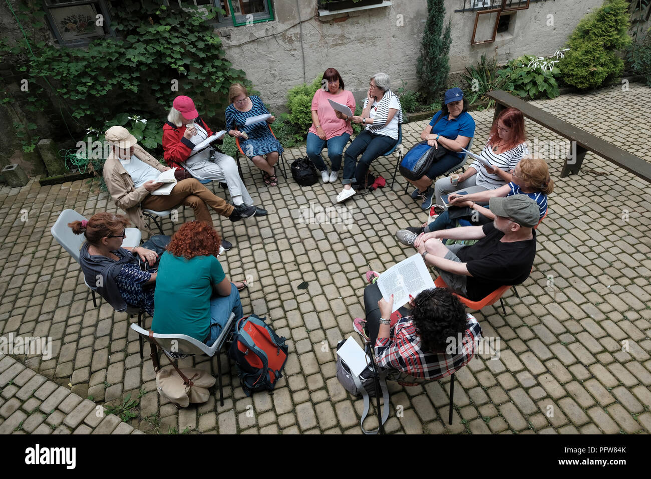 I partecipanti dell'agenzia turistica ROOTKA, specializzata in tour del patrimonio ebraico nell'Europa orientale, leggono estratti di scrittura Agnon nel cortile interno della casa in cui nacque Shmuel Yosef Agnon, uno scrittore ebreo premio Nobel che fu una delle figure centrali della fiction ebraica moderna Nella città di Buchach, un tempo sede di una grande comunità ebraica, fu annientata brutalmente dai tedeschi durante la seconda guerra mondiale a Ternopil Oblast (provincia) nell'Ucraina occidentale. Foto Stock