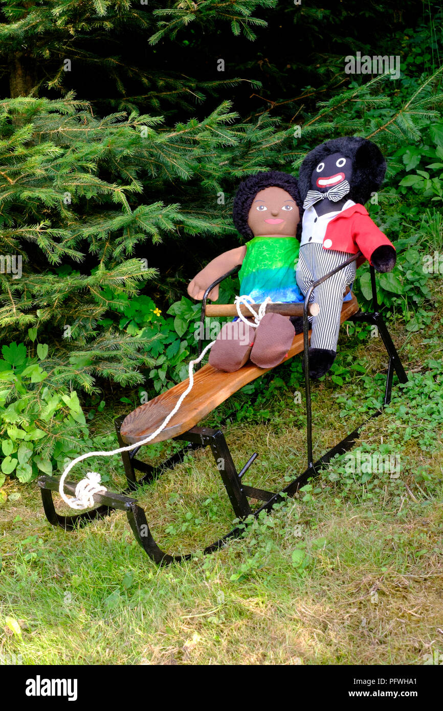 Golliwog e marrone e Soffice bambola giocattolo seduto sulla piccola slitta con alberi di Natale dietro Zala county Ungheria Foto Stock