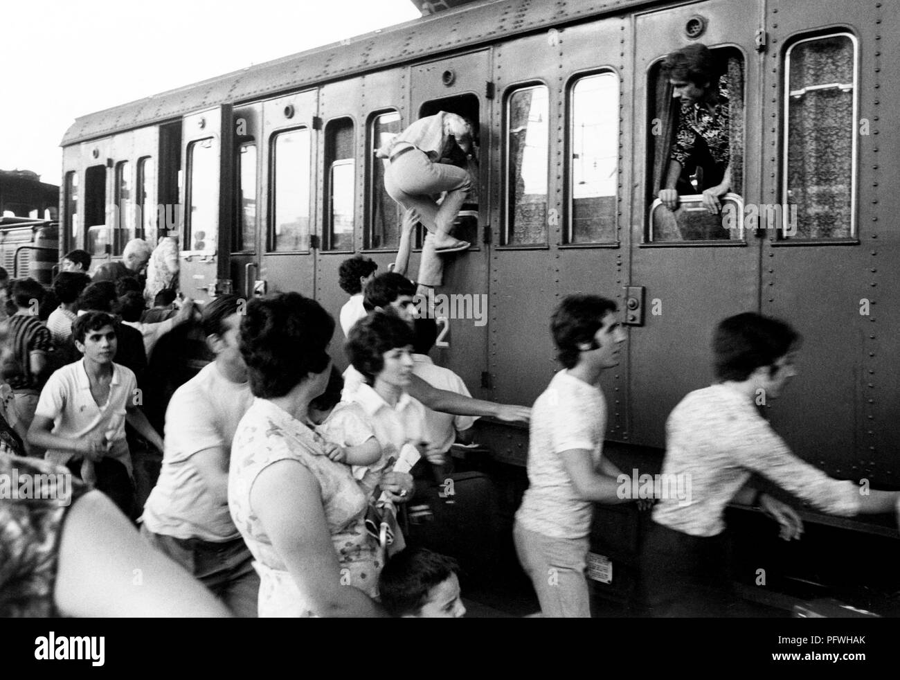 Passeggeri presso la stazione durante l'estate l'esodo, Italia 70s Foto Stock