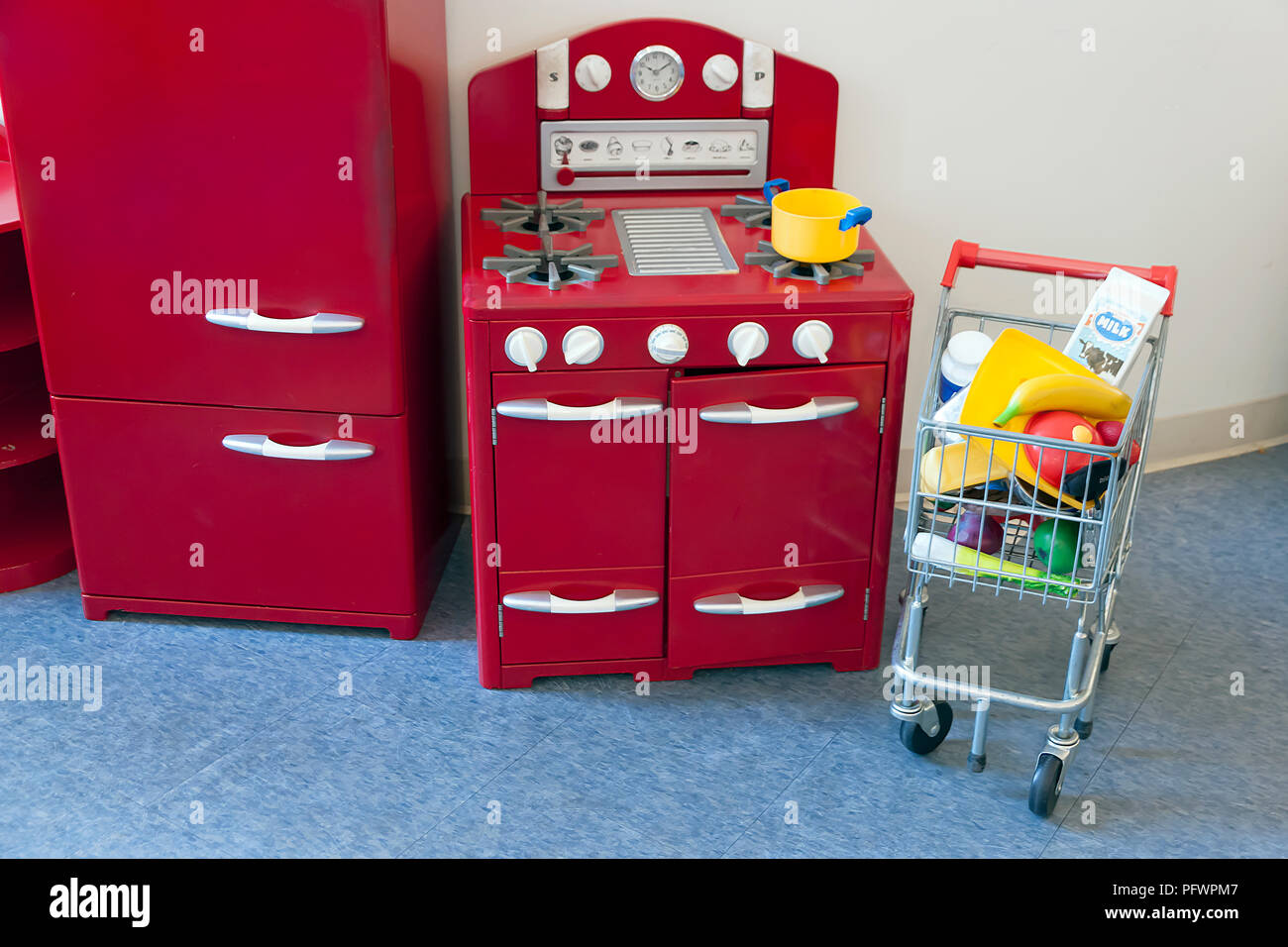 Piano di cottura, forno, frigorifero e carrello giocattoli per bambini. Foto Stock
