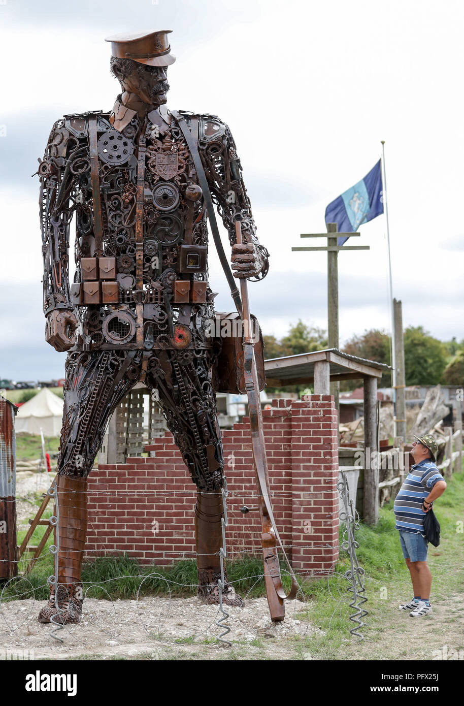 Una persona che guarda alla scultura "l'ossessione" fatta di rottami di metallo per artista e fabbro Martin Galbavy, che si trova all' ingresso della guerra mondiale 1 area presso la grande Dorset fiera del vapore, dove centinaia di periodo i motori a trazione a vapore e pesanti attrezzature meccaniche appartenenti a tutte le epoche si riuniscono per la mostra annuale del 23 al 27 agosto 2018, per celebrare i 50 anni. Foto Stock