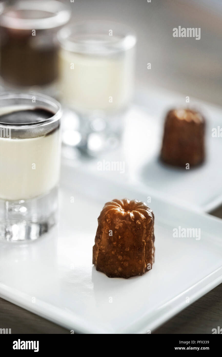 Torta francese canele su una piastra e crema vaniglia su una lastra di vetro Foto Stock