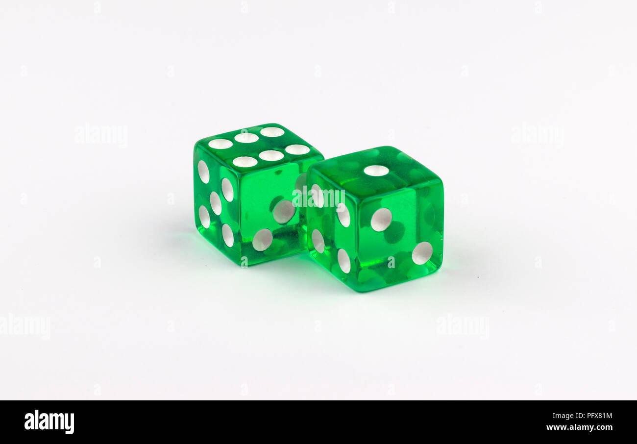 Una coppia di verde traslucido dadi di gioco su uno sfondo bianco, con macchie bianche che mostra diverse combinazioni che aggiungere fino a numero fortunato sette Foto Stock