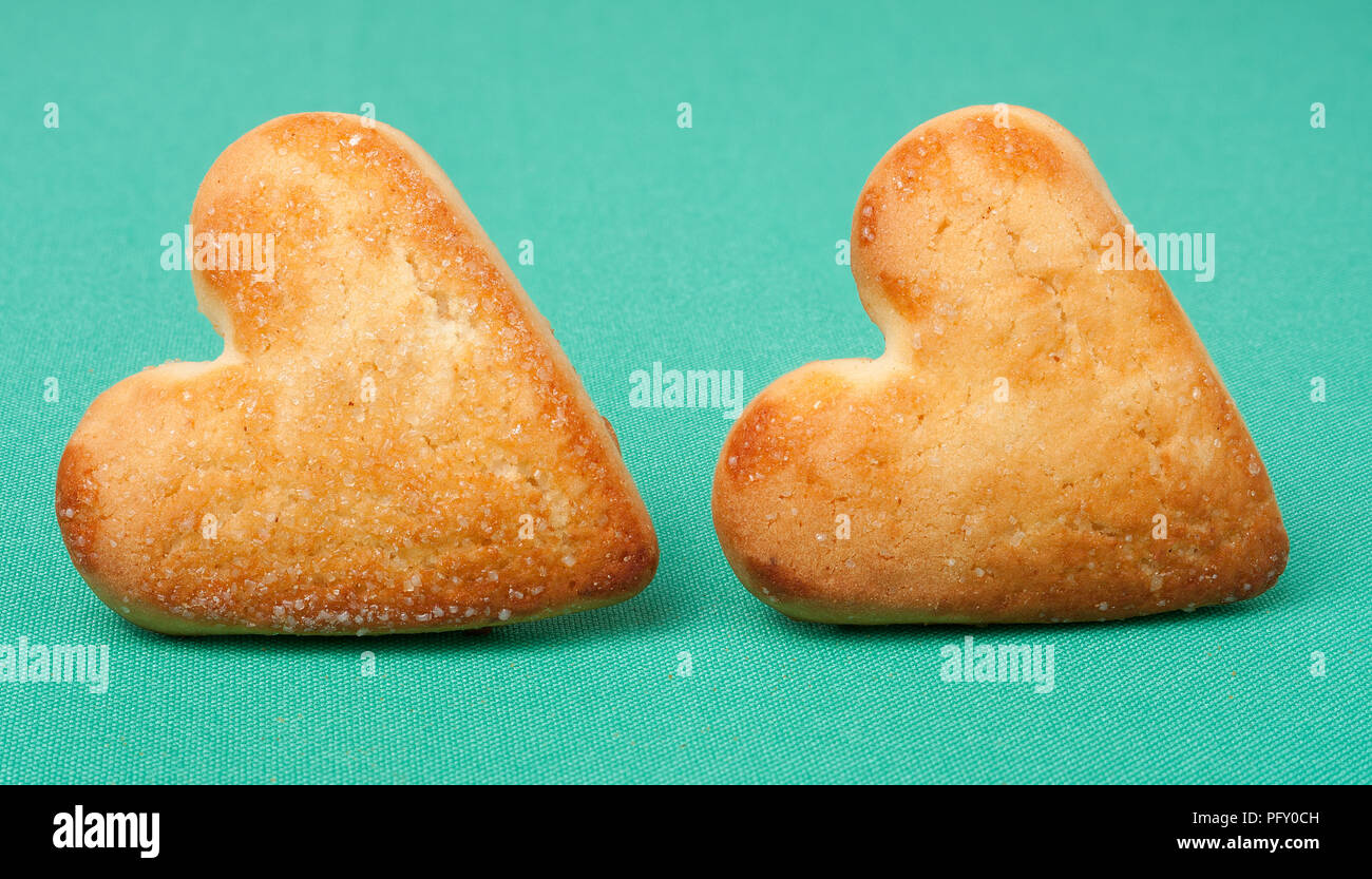 Biscotti a forma di cuore su sfondo verde Foto Stock