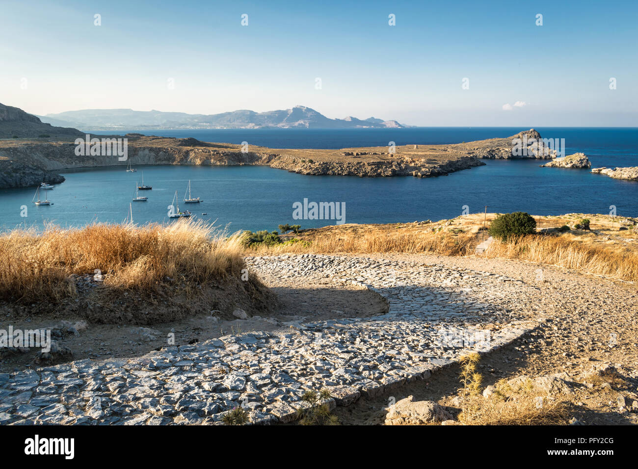Thi è la vecchia strada di pietra che le curve che fino all'acropoli di Lindos sul isola greca di Rodi. Foto Stock