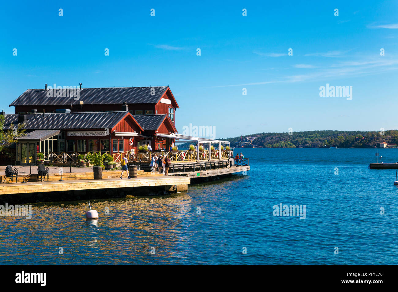 Vista panoramica del mare e rossi tradizionali case svedesi in Fjaderholmarna, arcipelago di Stoccolma, Svezia Foto Stock
