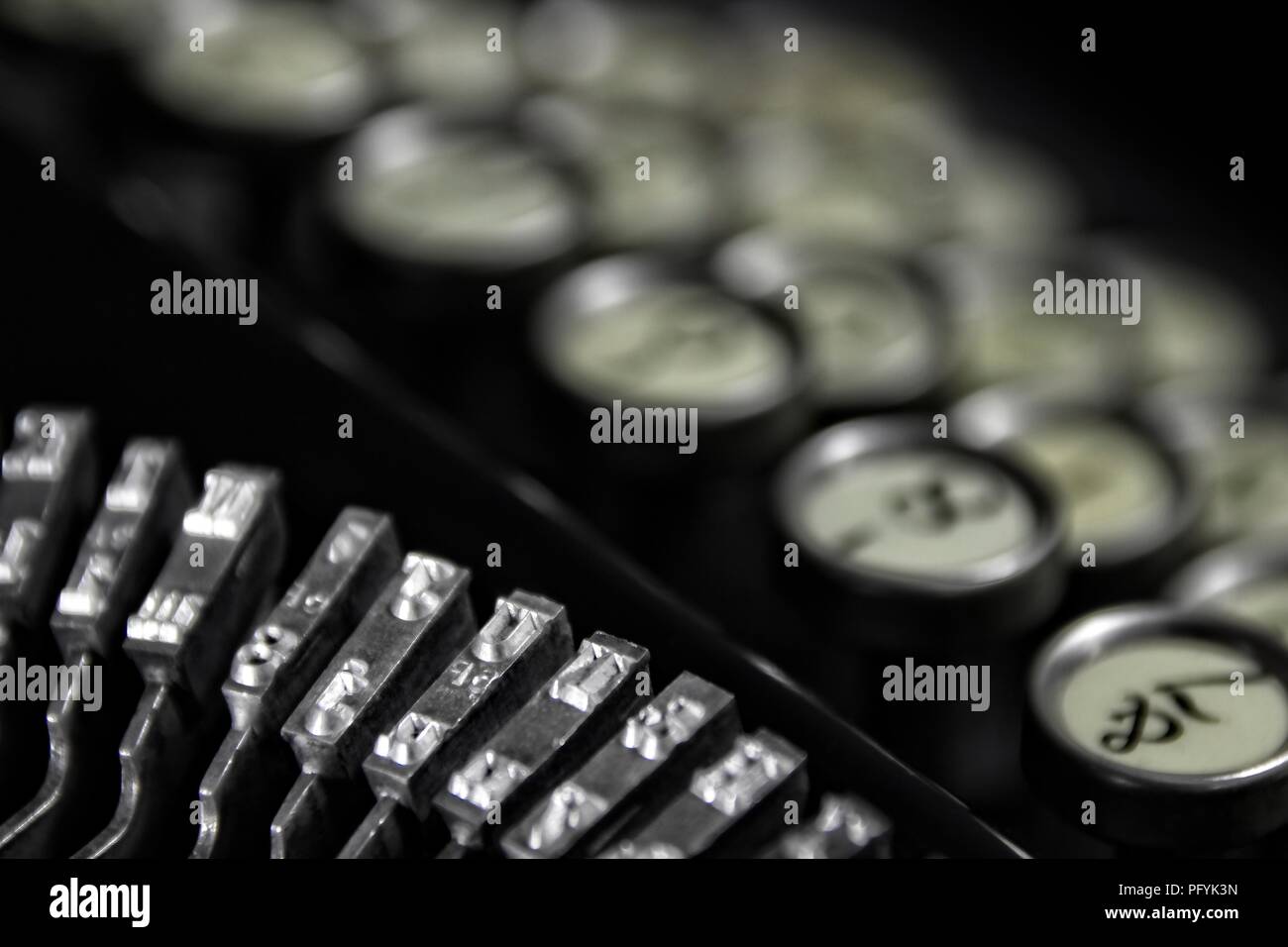 Vintage Keyboarding: Classic 1923 Nastri inchiostratori per macchine da scrivere con la tastiera bokeh di fondo e sfondo nero. Adatto per hotel/motel che sono in grado di soddisfare una clientela business. Foto Stock