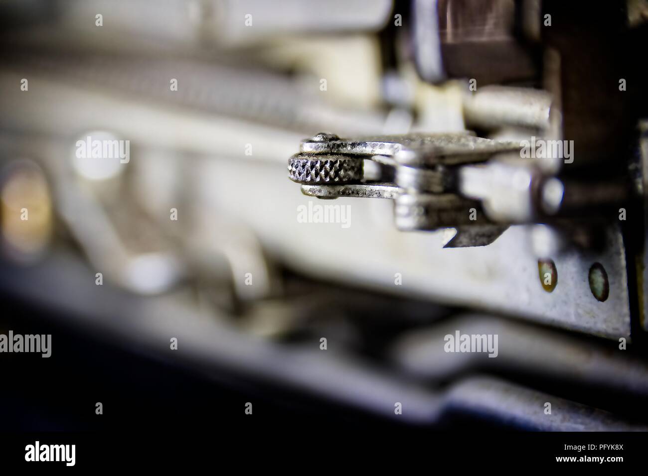 Orientata fino; fotografia che mostra un meccanismo di ingranaggi su un 1923 Nastri inchiostratori per macchine da scrivere con un bokeh sfondo. Lo strato di sottofondo adatto per affari e per uso industriale. Foto Stock