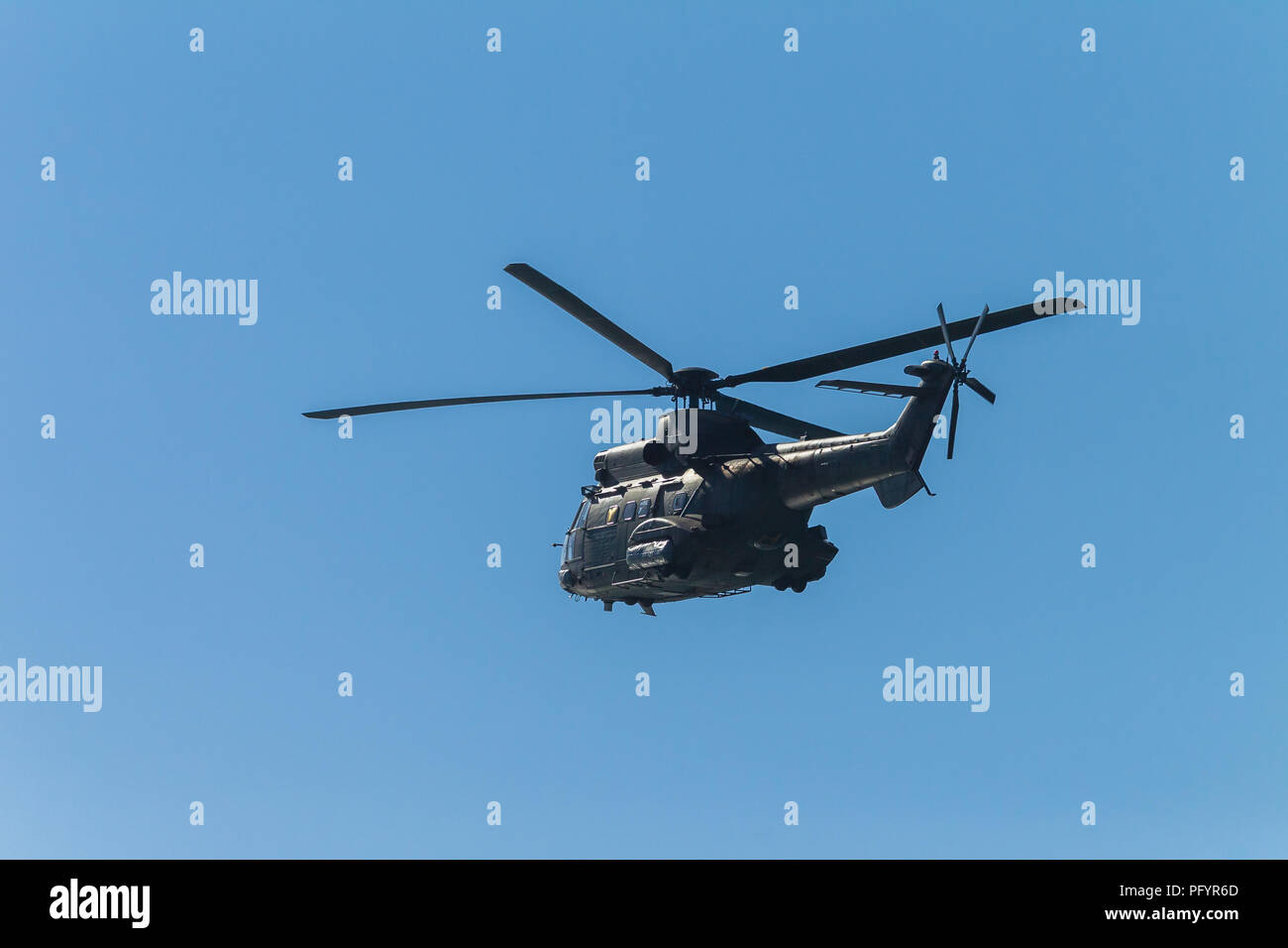Grande militare elicottero volando patrol stagliano blue sky. Foto Stock