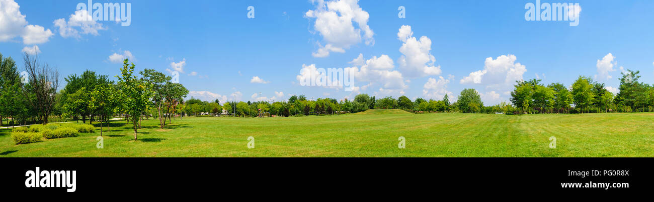 Panorama di prato verde campo con alberi in background. Parco di Palazzo Mogosoaia vicino a Bucarest, Romania. Foto Stock