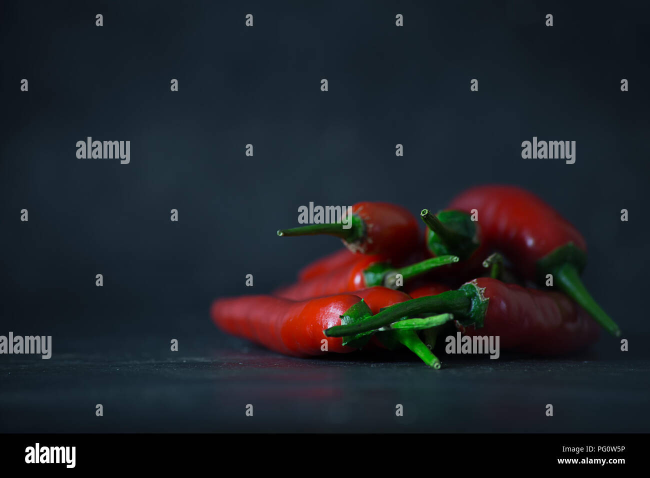 Un sacco di peperoncino rosso in pietra scura terra Foto Stock