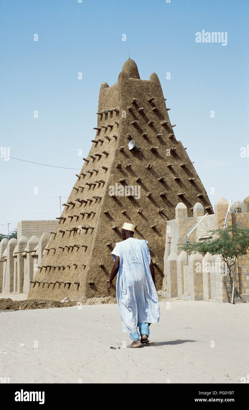 Uomo in vesti bianche a camminare verso la moschea di Sankore in Timbuktu, Mali per solo uso editoriale Foto Stock