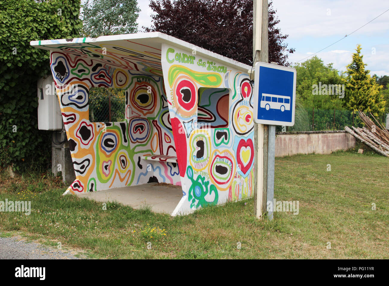 Paese shelter bus dipinte a mano in pyschedelic graffiti da scolari in villaggio in Francia Foto Stock