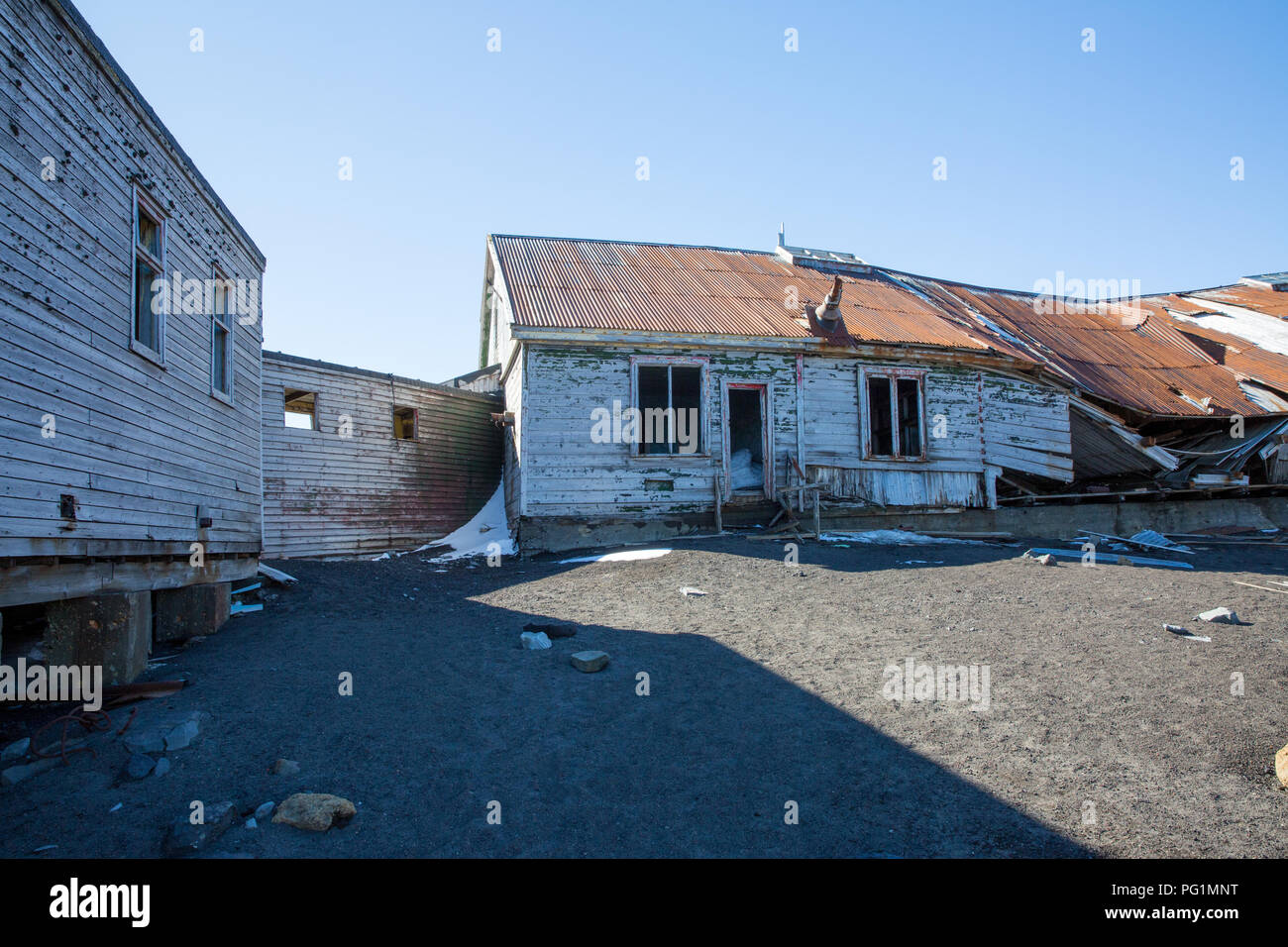 Un vecchio villaggio di pescatori nelle montagne dell'Antartide con vecchie case Foto Stock