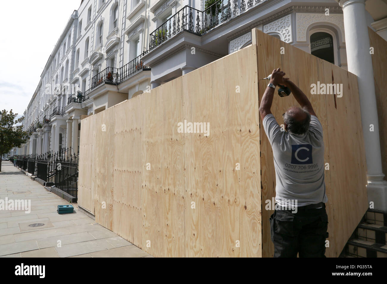 A ovest di Londra. Regno Unito 23 agosto 2018 - un operaio di salire a bordo di una proprietà residenziale davanti al carnevale di Notting Hill che si svolgerà questo weekend. Credito: Dinendra Haria/Alamy Live News Foto Stock