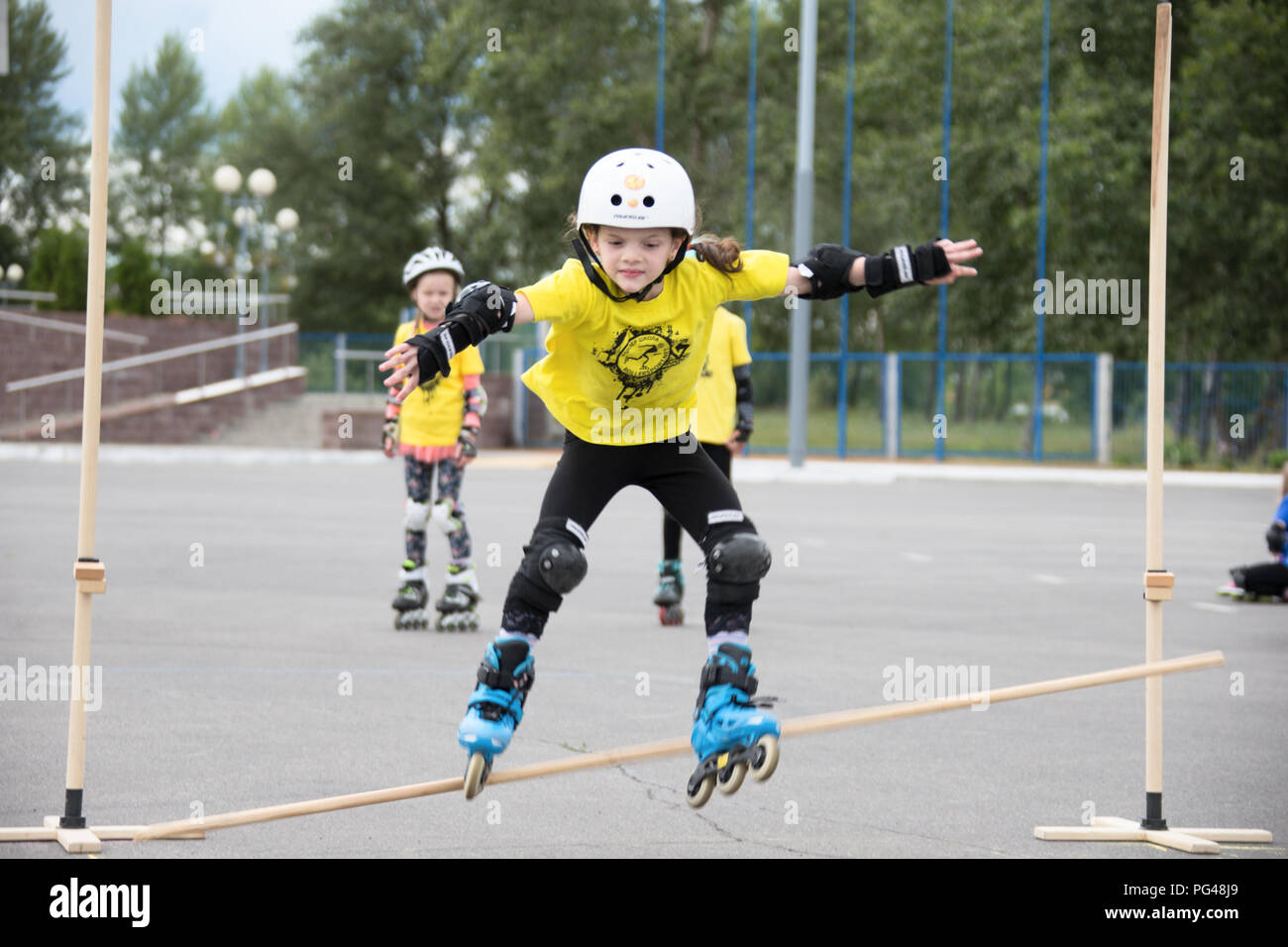 La Bielorussia, Gomel, Giugno 24, 2018. Central Park. I bambini della concorrenza nel rullo sport.La ragazzina salta su rulli attraverso un barbell Foto Stock