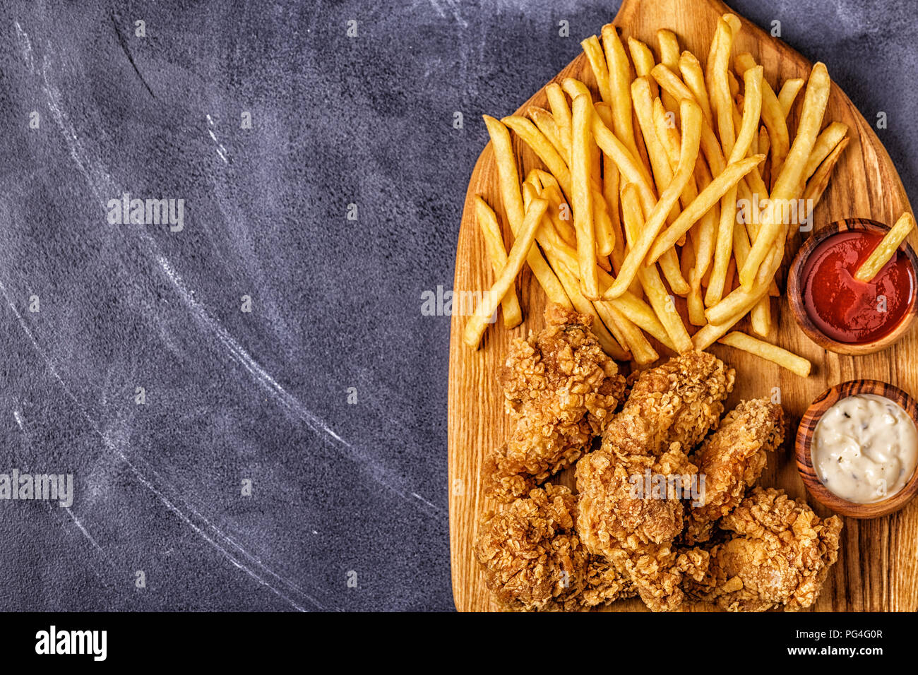 Alette di pollo fritte con patatine fritte, vista dall'alto. Foto Stock
