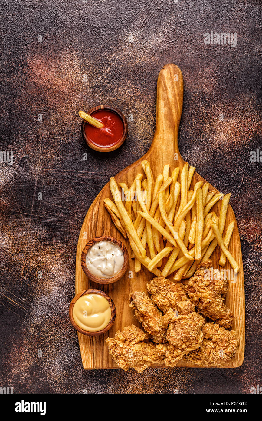 Alette di pollo fritte con patatine fritte, vista dall'alto. Foto Stock
