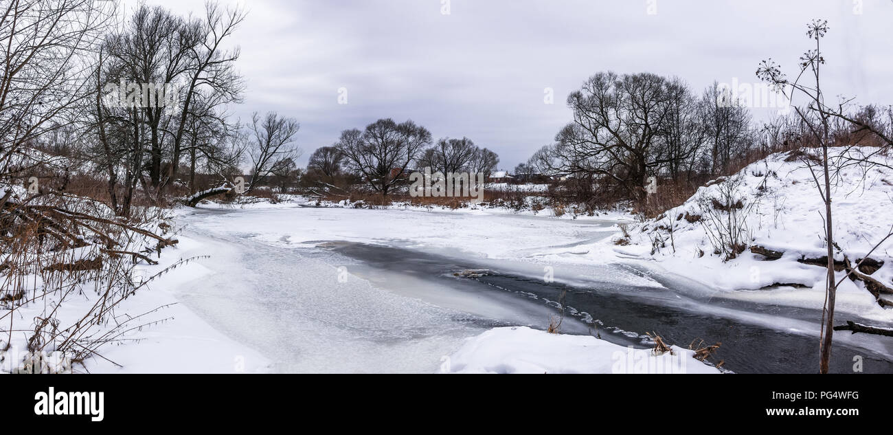 Panorama del paesaggio con alberi innevati e bellissimo fiume congelato Foto Stock