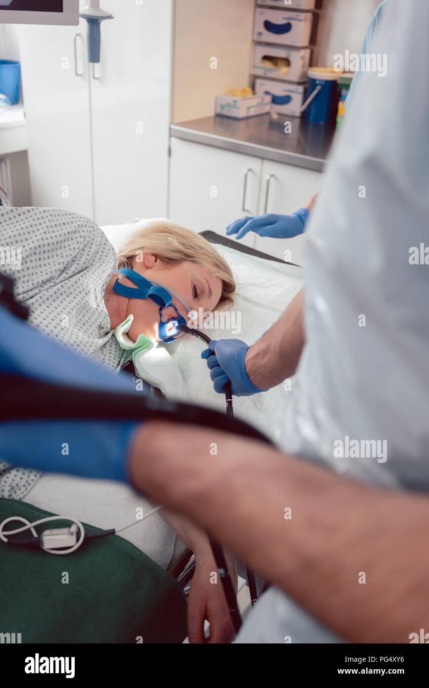 Medico tenendo endoscopio durante gastroscopia in mano Foto Stock