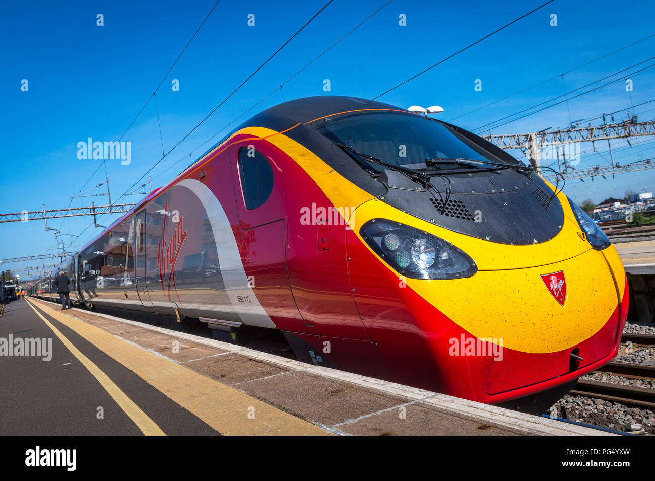 Treni del Virgin pendolino classe 390 electric treno ad alta velocità che arrivano in corrispondenza di una stazione ferroviaria sulla linea di Abbazia, Hertfordshire, Regno Unito. Foto Stock