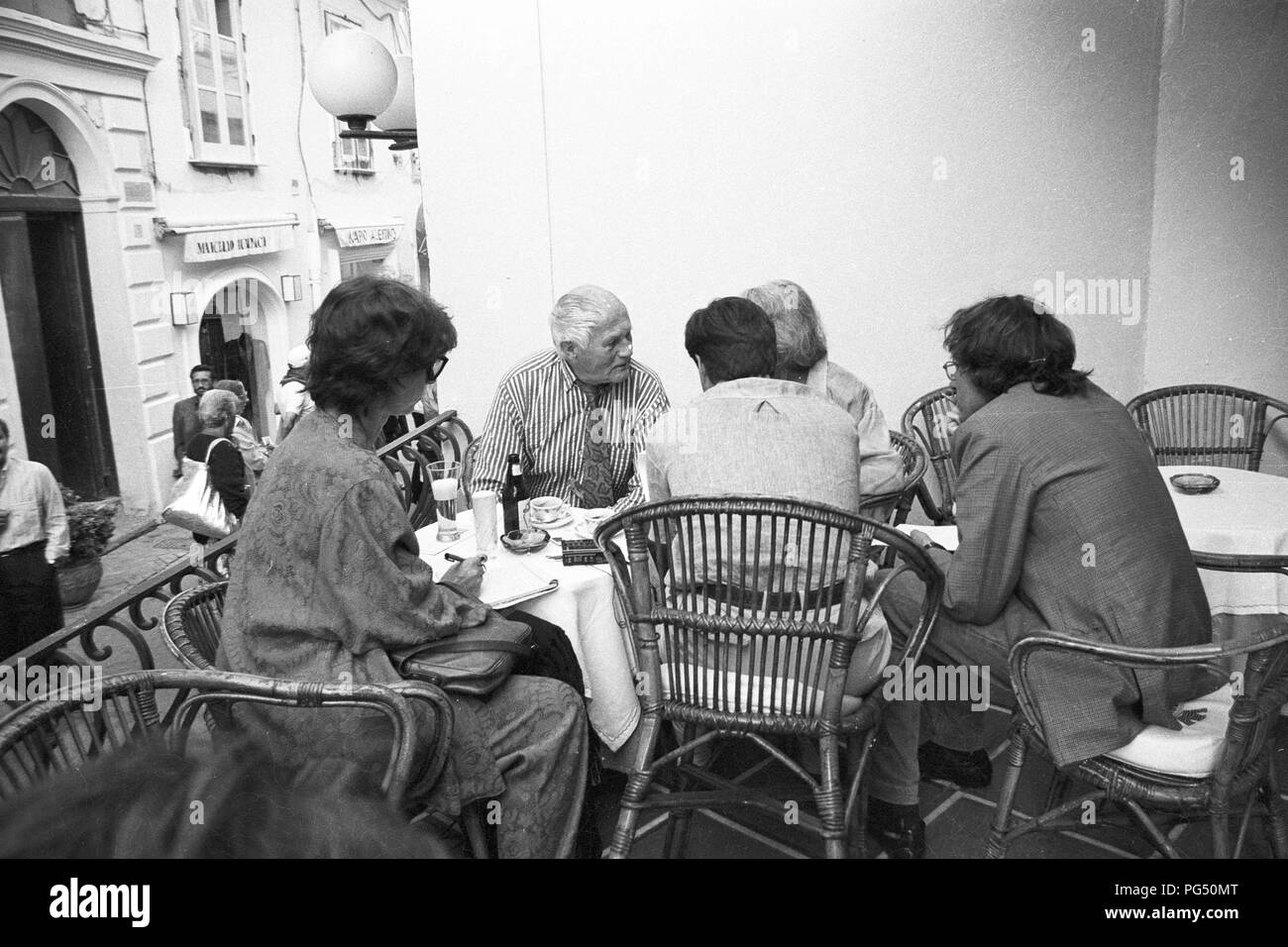 Lo scrittore Bohumil Hrabal (centrale) e il suo traduttore Susanna Roth in un ristorante a Capri. Foto Stock