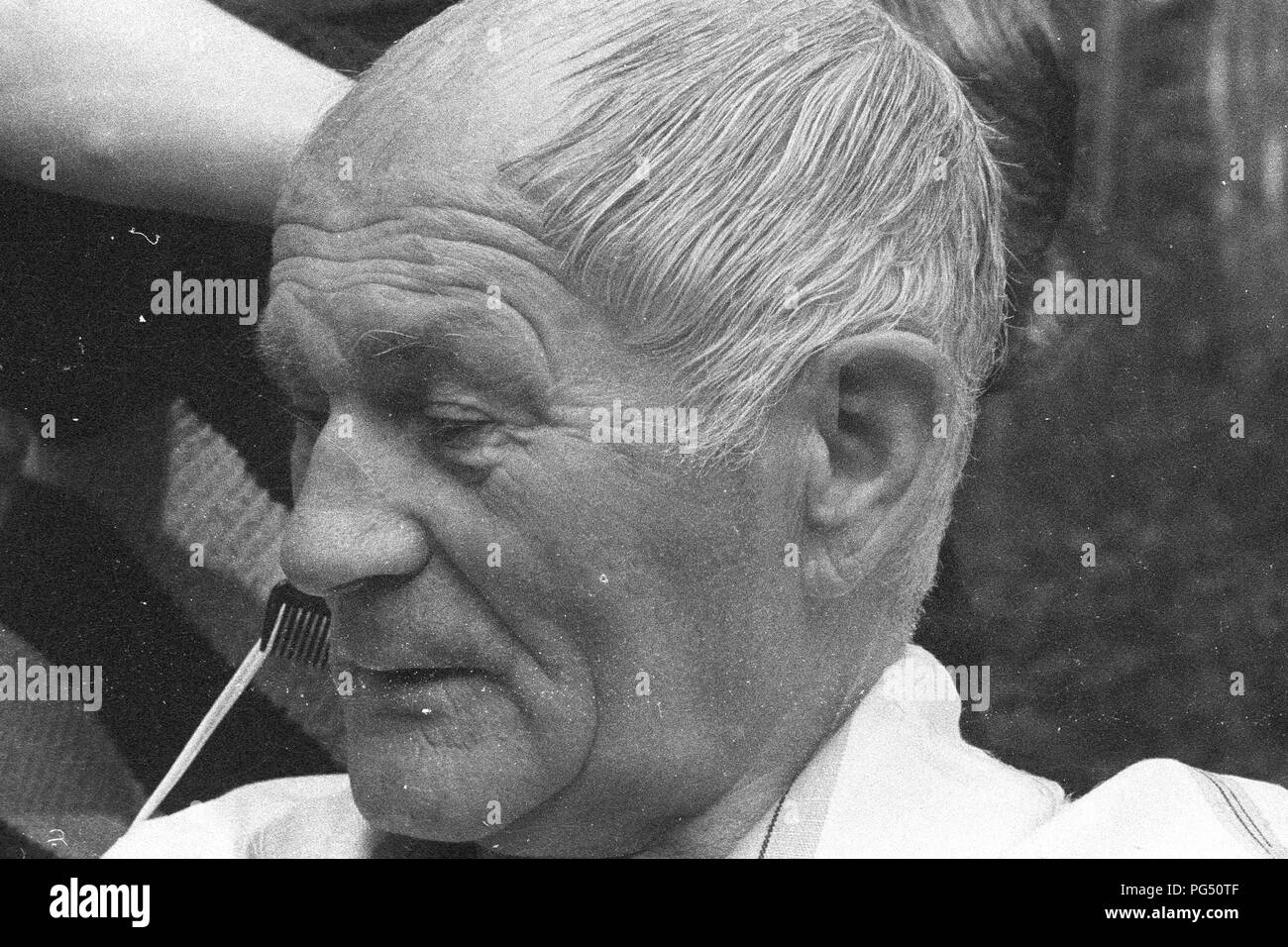 Il scrittore ceco Bohumil Hrabal ottiene il suo taglio di capelli nel giardino della sua casa estiva di Kersko vicino a Praga. Foto Stock