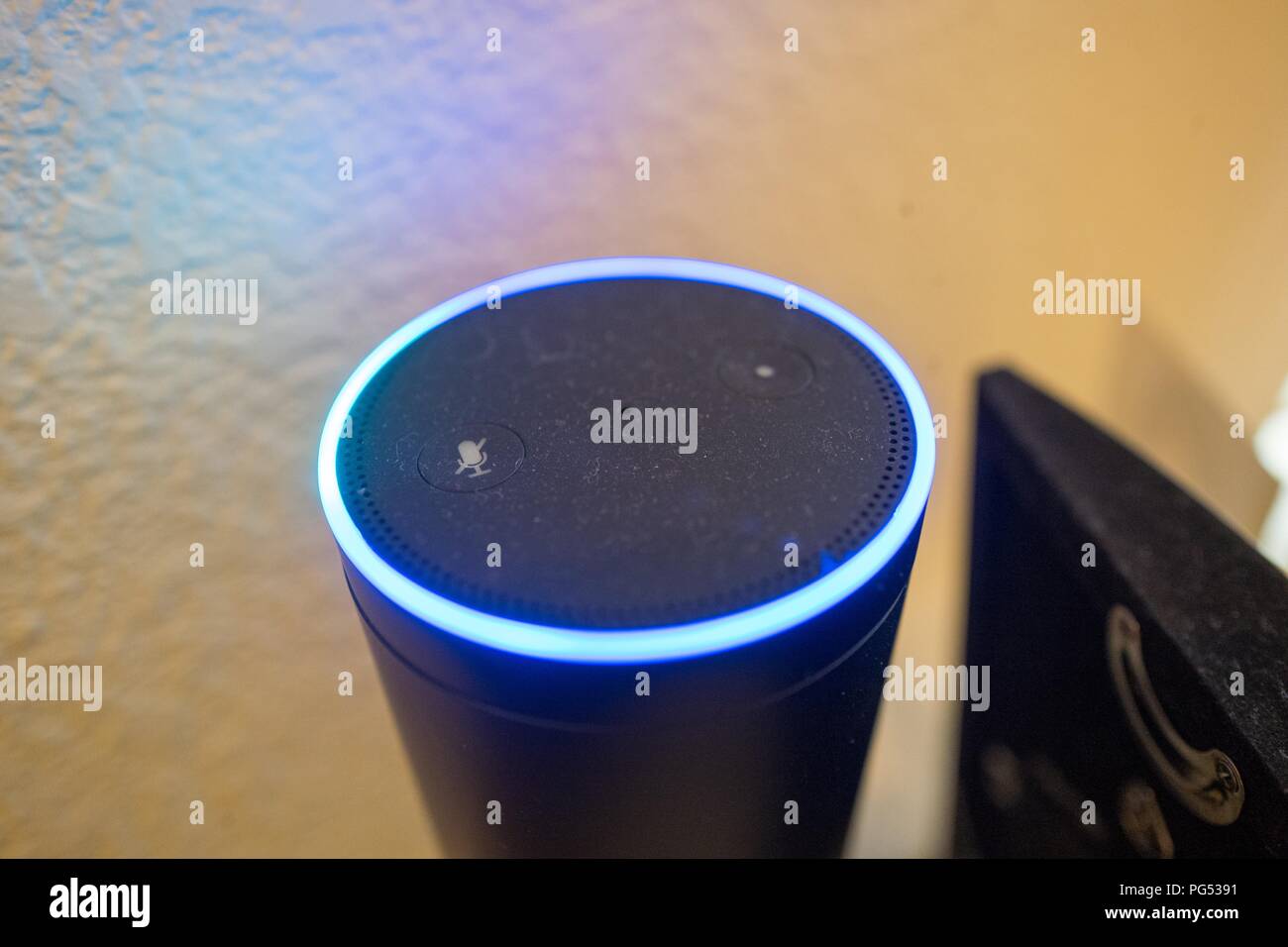 Close-up di Amazon eco Altoparlante smart e Assistente vocale illuminato con luce blu anello, un dispositivo che utilizza il servizio Amazon da Amazon per riconoscere e rispondere agli utenti dei comandi vocali, in una casa suburbana impostazione, 7 maggio 2018. () Foto Stock