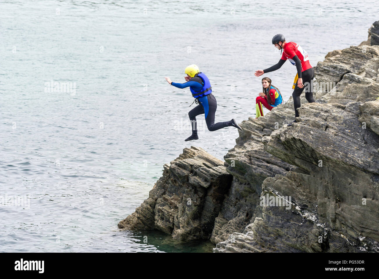 I villeggianti coasteering sul promontorio in Newquay, Cornwall. Foto Stock