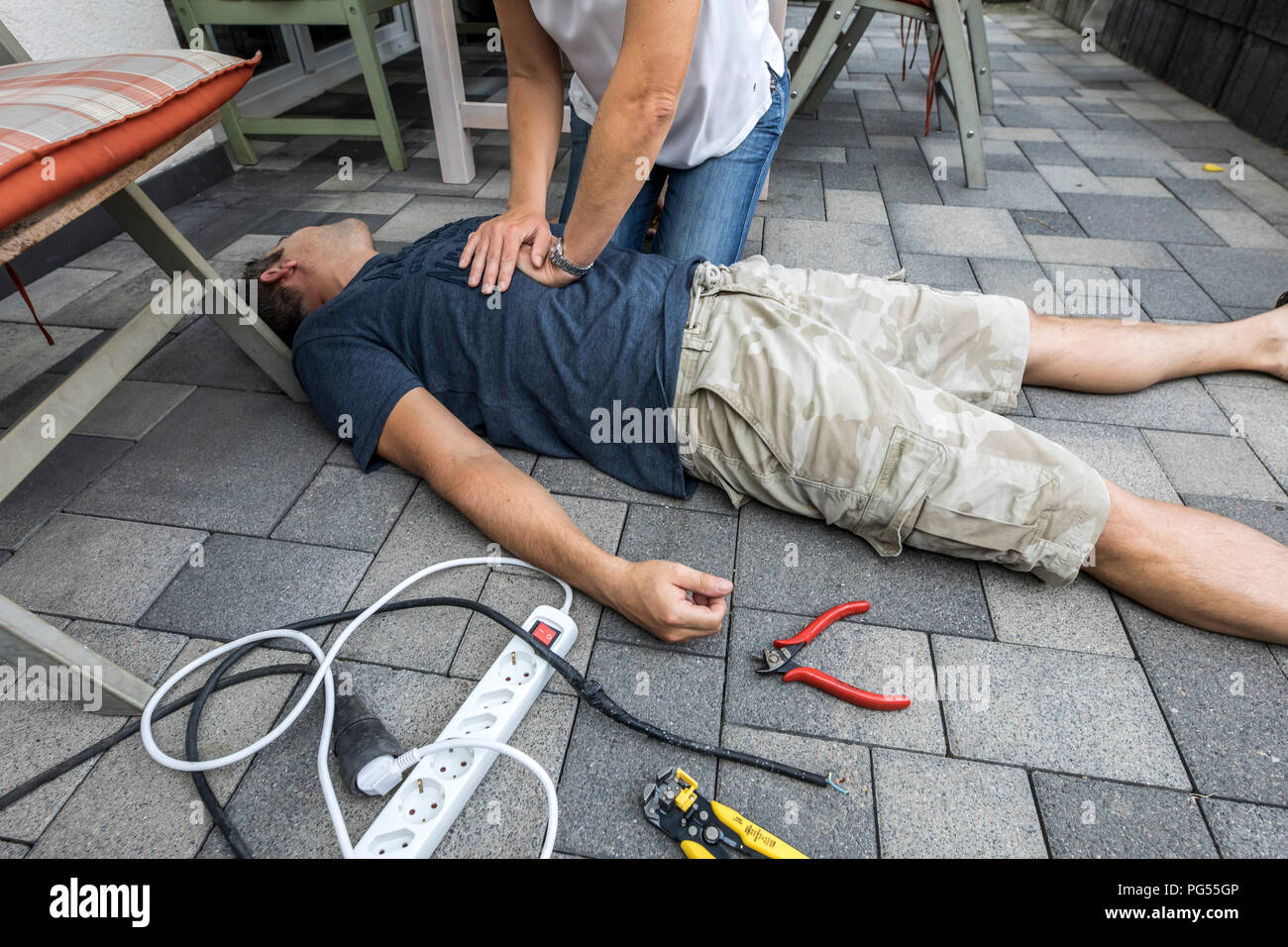 Immagine simbolica, primo soccorso, scena pubblicato, rianimazione con una pressione cardiaca massaggio dopo il collasso circolatorio causato da un corto circuito elettrico circui Foto Stock