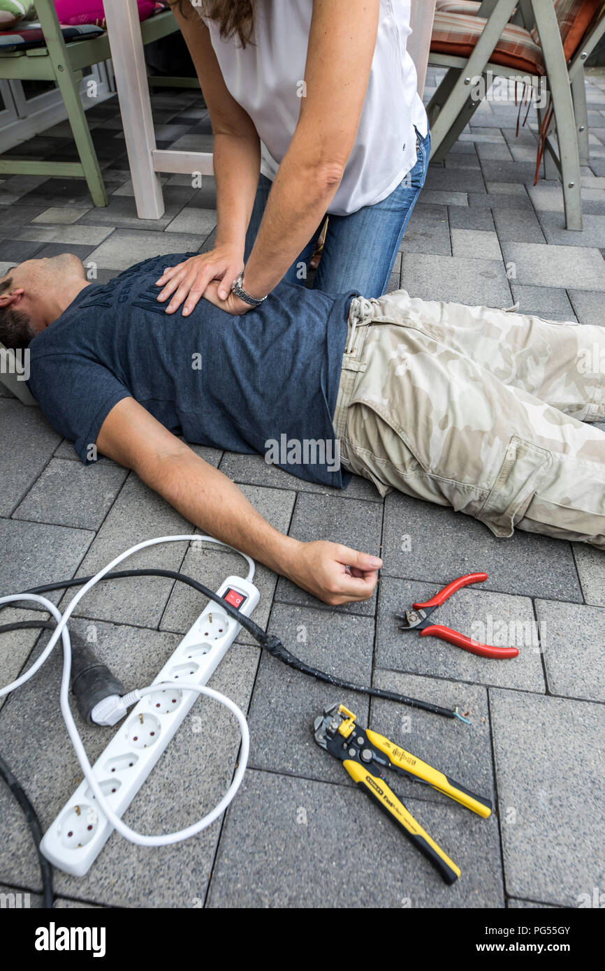 Immagine simbolica, primo soccorso, scena pubblicato, rianimazione con una pressione cardiaca massaggio dopo il collasso circolatorio causato da un corto circuito elettrico circui Foto Stock