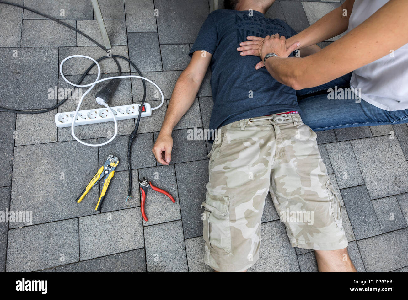 Immagine simbolica, primo soccorso, scena pubblicato, rianimazione con una pressione cardiaca massaggio dopo il collasso circolatorio causato da un corto circuito elettrico circui Foto Stock