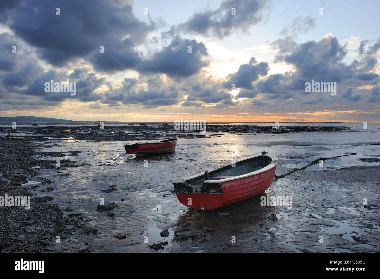 Piccole imbarcazioni in acque basse. Thurstaston, Wirral, Cheshire, Dee estuario. Un drammatico cielo tempestoso sopra e la costa del Galles Settentrionale della distanza Foto Stock