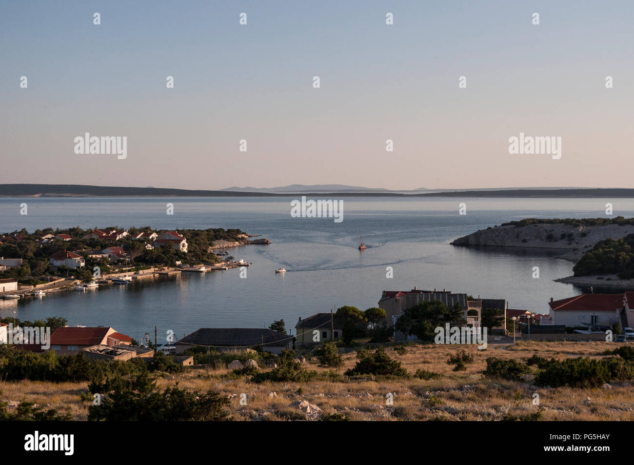 Croazia: vista panoramica al tramonto della macchia mediterranea e il porto di Gajac, un telecomando piccolo villaggio sull'Isola di Pag nel mare Adriatico Foto Stock