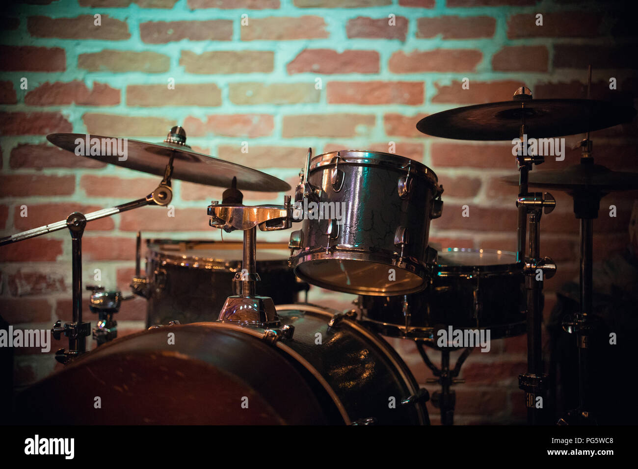 Un bel cesto si erge contro un muro di mattoni in un jazz bar Foto Stock